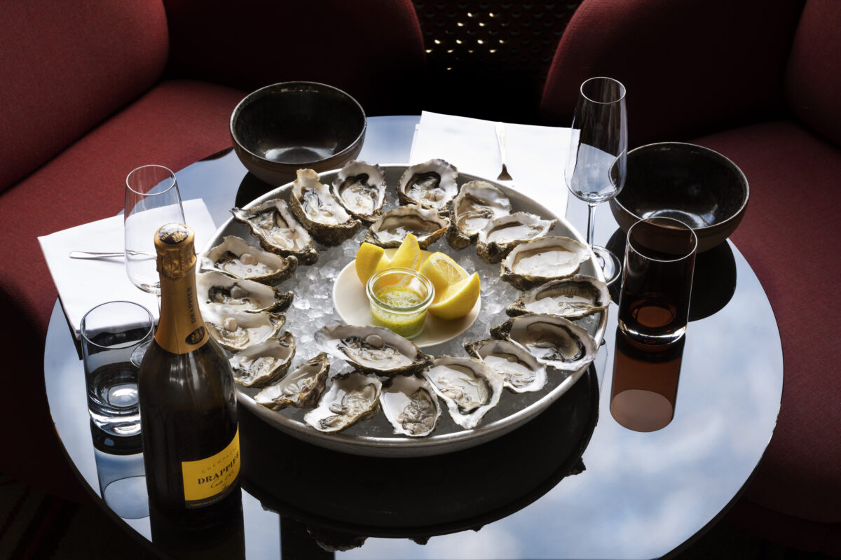 Austernplatte mit Champagner auf dem Spiegeltisch